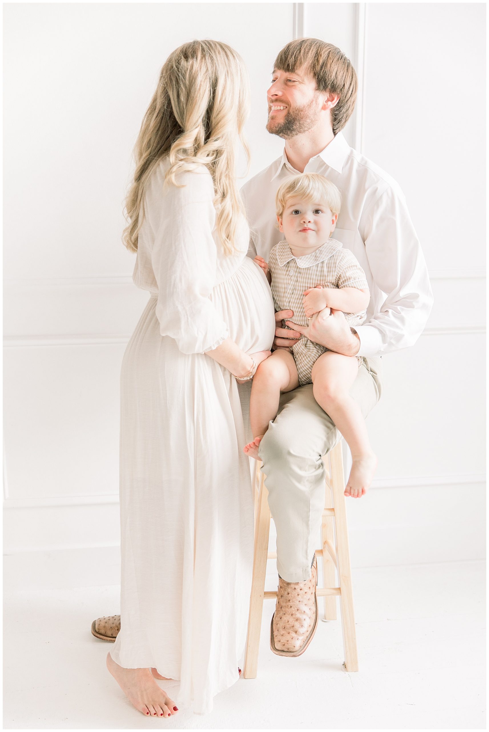 Family of 3 loving on each other during maternity photo session with Katie Petrick Photography
