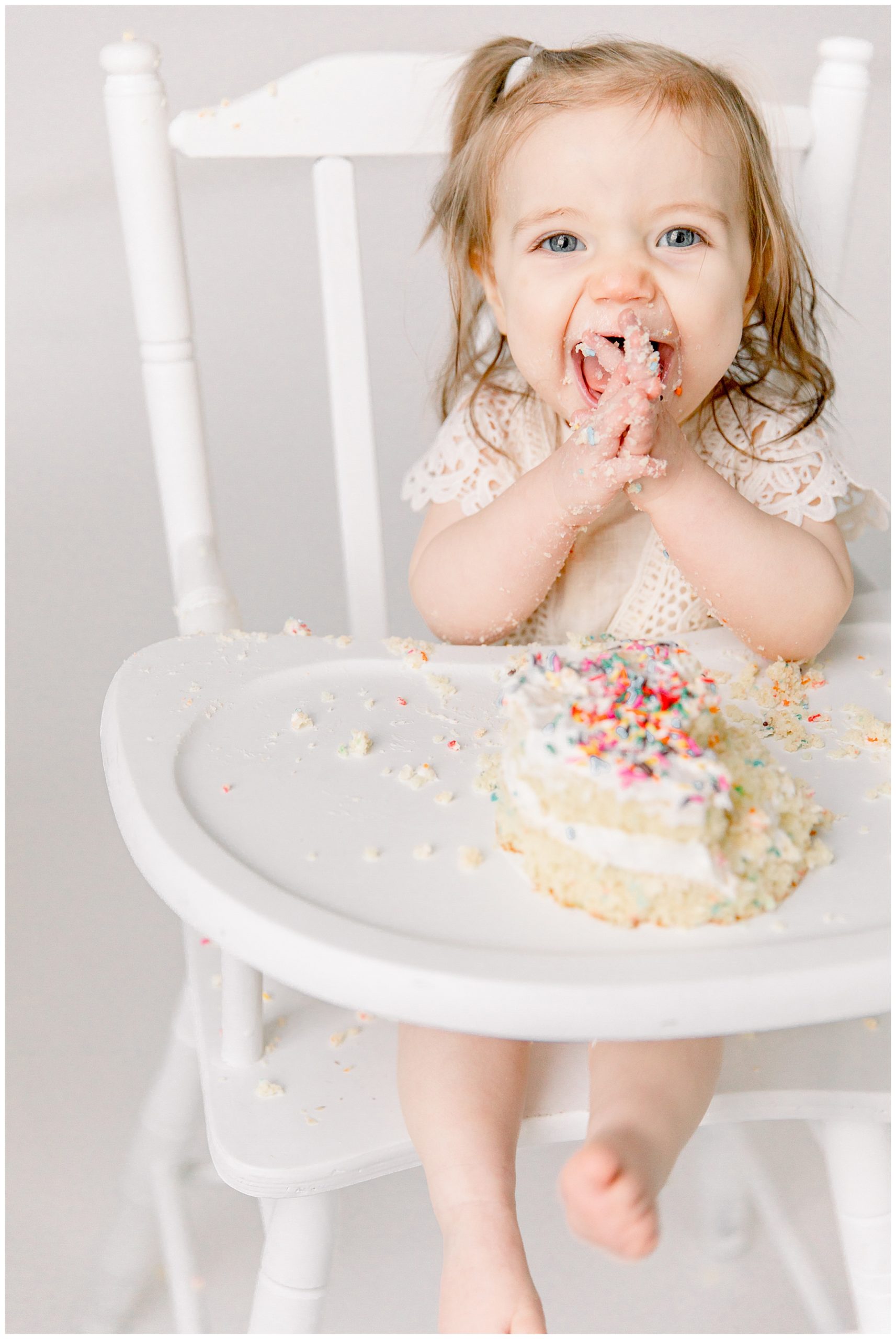 Baby girl smiling during her studio cake smash session by Charlotte baby photographer