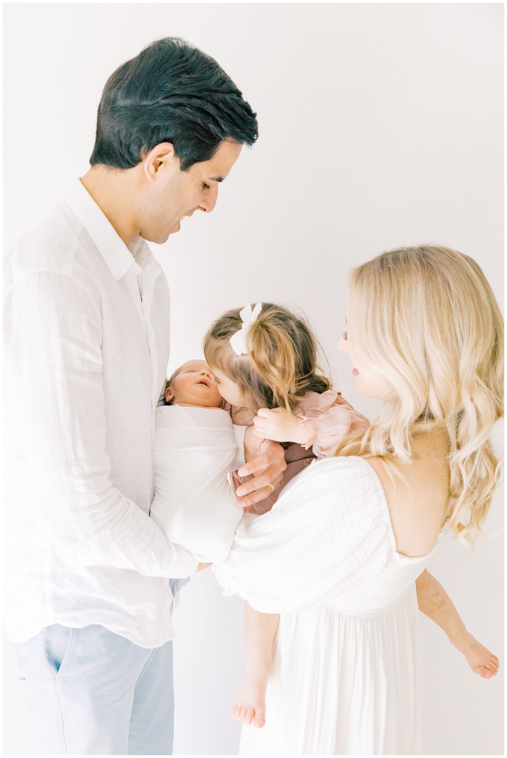 Mom and dad holding older daughter and newborn during family newborn session in Charlotte NC
